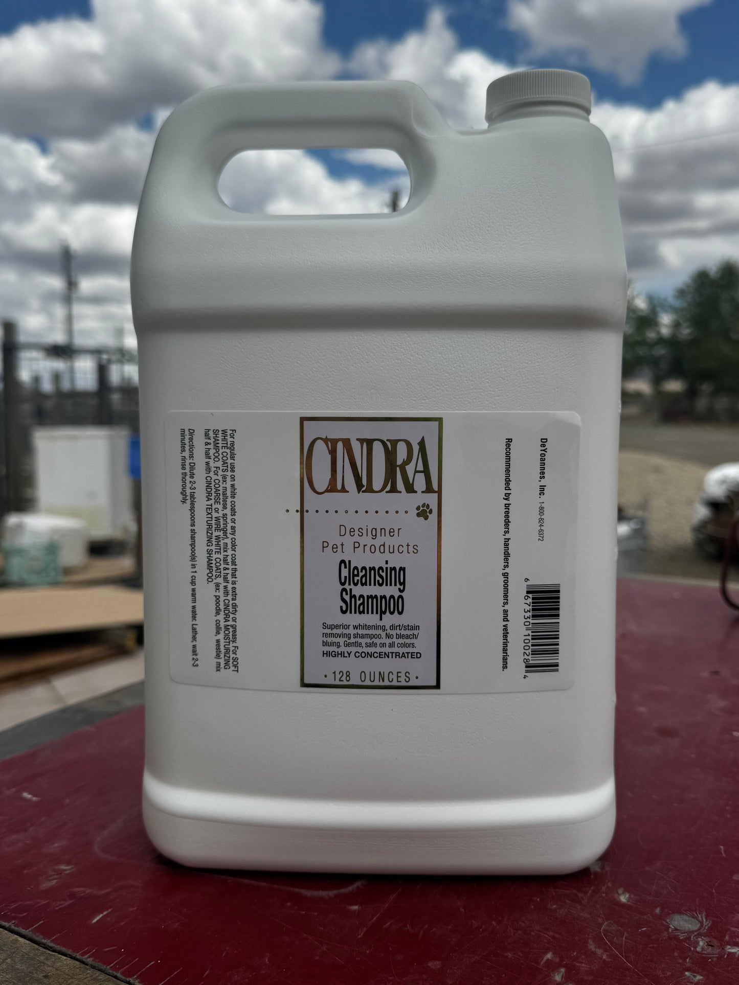 Large container of Cindra cleansing shampoo on a red surface with a snowy outdoor background.
