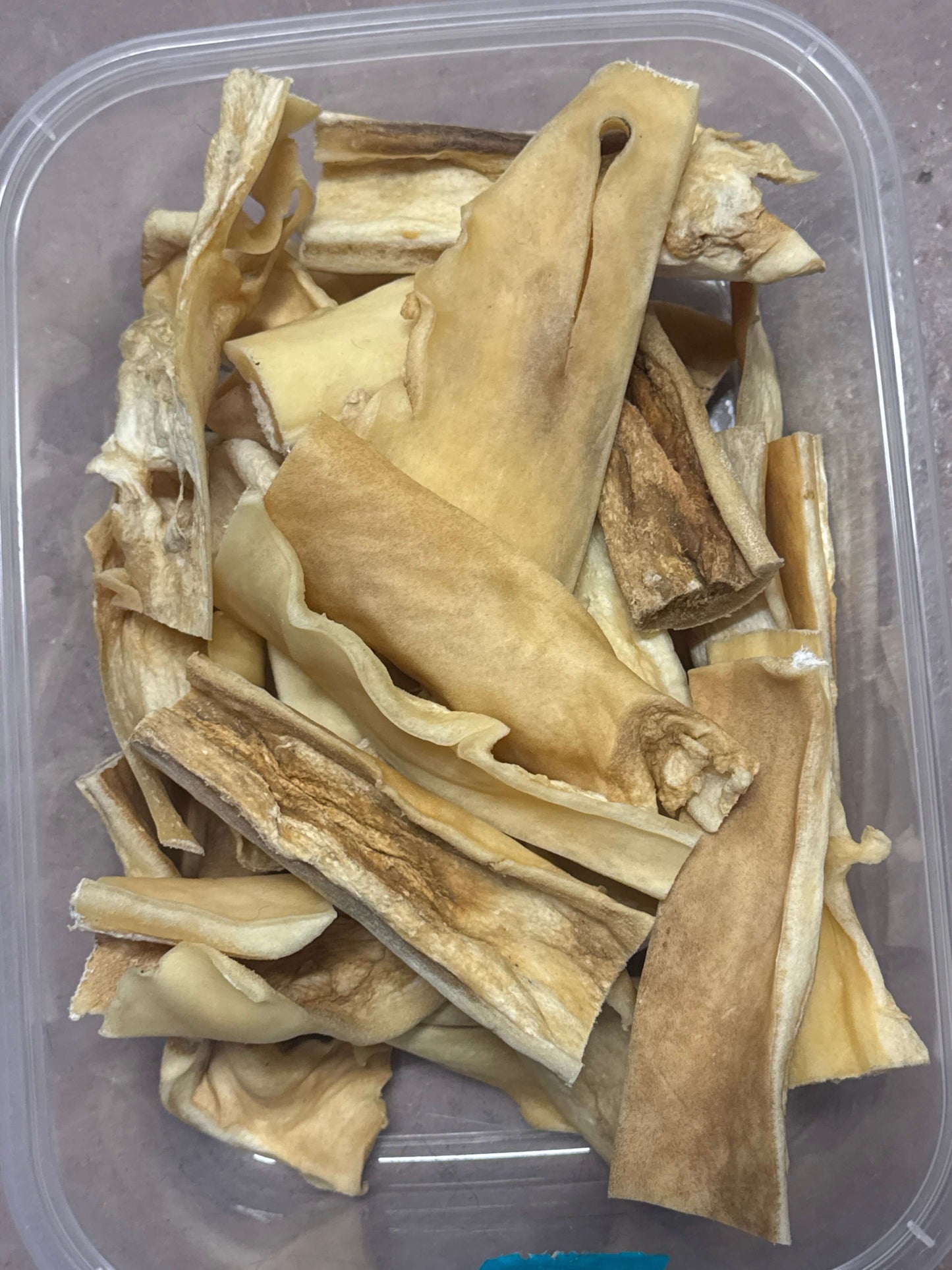 Dried cow hide in a clear plastic container