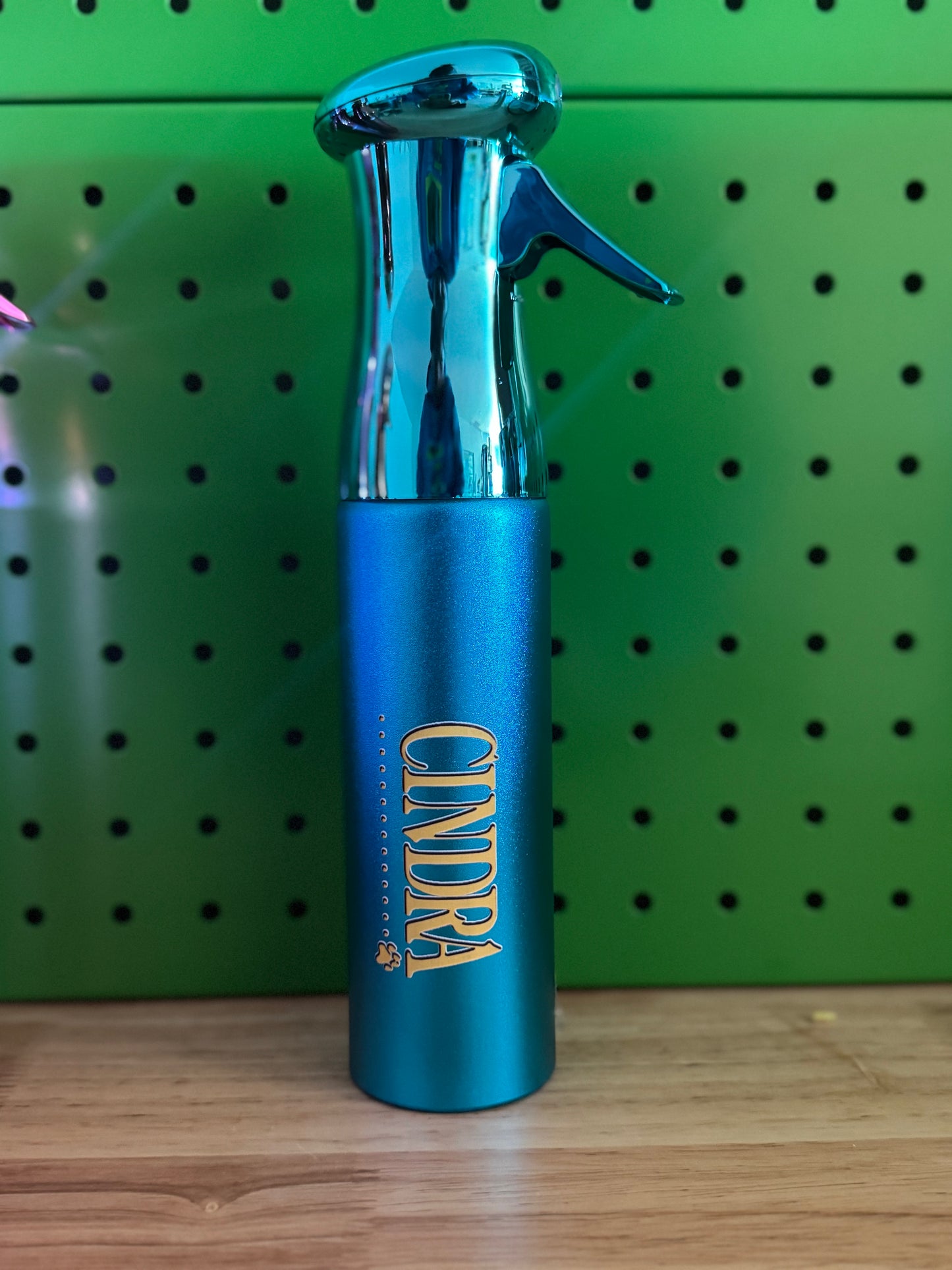 Blue Metallic water sprayer with a green background