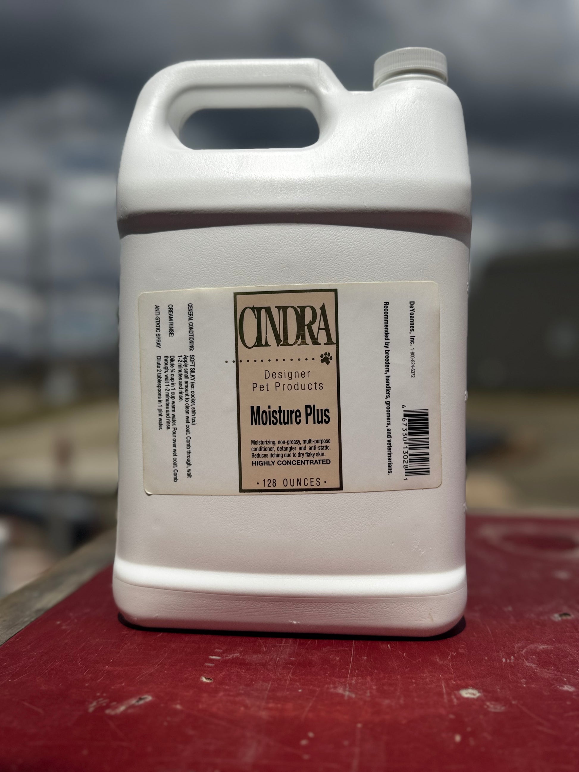 White container labeled 'Cindra' on a red surface with a blurred background