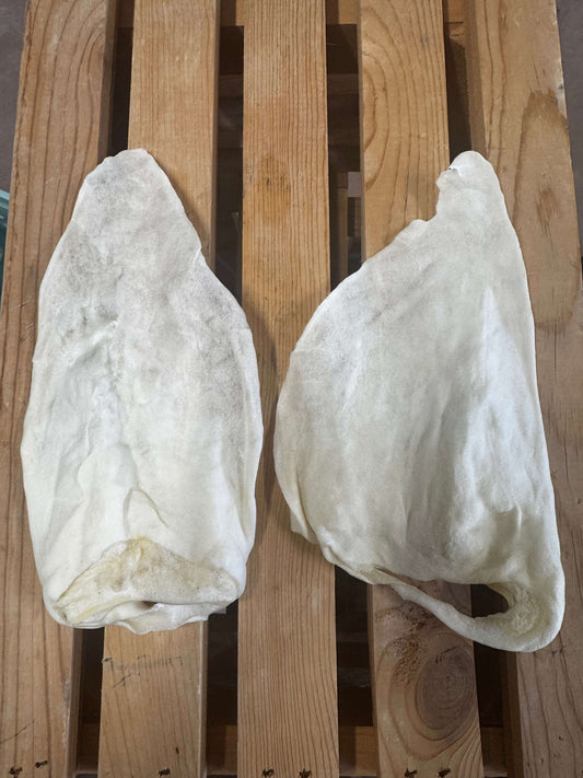 Two white cow ears on a wooden pallet