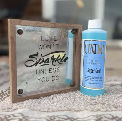 Cindra Super Coat dog grooming spray bottle beside decorative sign reading Life Won’t Sparkle Unless You Do on patterned surface
