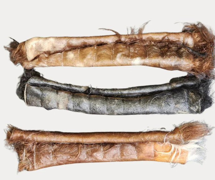 Three natural hair-on hide dog chew rolls in assorted colors on white background, long-lasting Ugly Chews by Cindra Pet Products